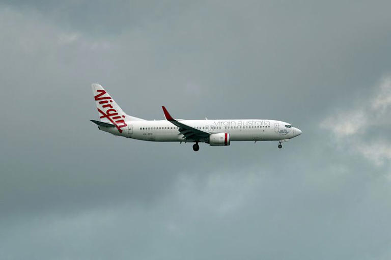 A Virgin flight from Perth to Melbourne was forced to turn back after a naked passenger aboard became erratic and knocked a crew member to the ground