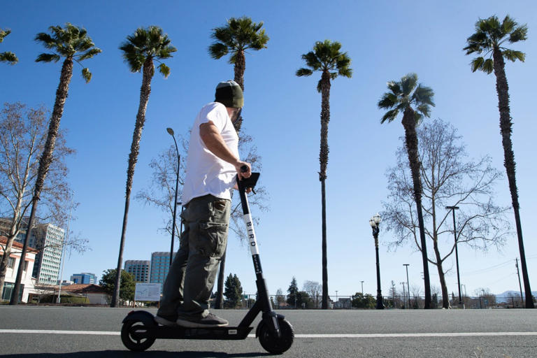 A person rides a scooter on West Santa Clara Street in San Jose. Bird today announced that the company has successfully emerged from Chapter 11 proceedings under a newly organized private parent company called Third Lane Mobility Inc. (Randy Vazquez/ Bay Area News Group)