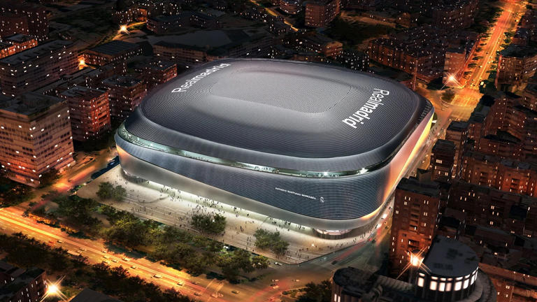 A rendered aerial view of the newly renovated Santiago Bernabéu Stadium in Madrid, Spain, illuminated at night. Taylor Swift’s Eras Tour is set to mark a significant milestone as the American singer performs at the historic venue.