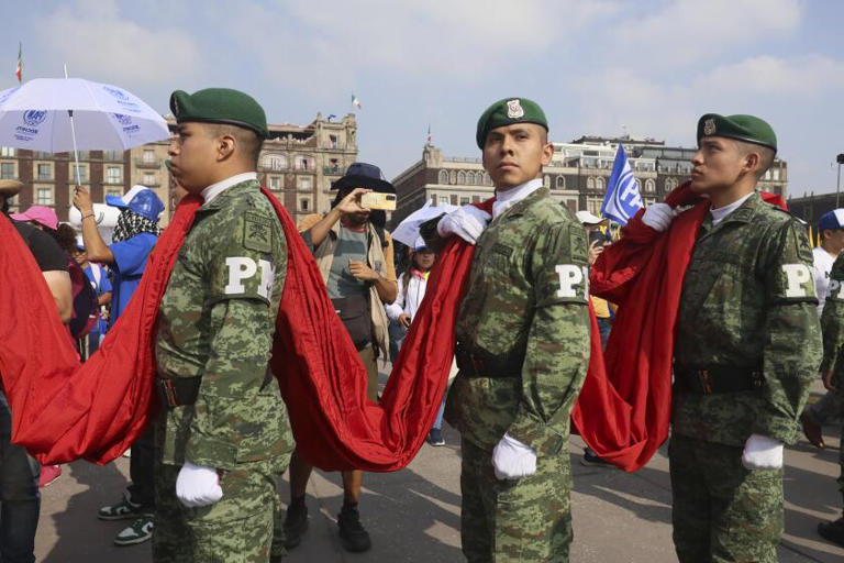 Members of the Mexican military hold the nation's flag before an opposition rally at the Zócalo, Mexico City's main square, this month as Mexico gears up for national elections this weekend. ((Ginnette Riquelme / Associated Press))