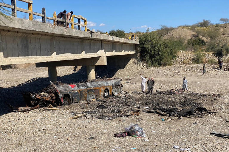 Residents look at the wreckage of a passenger bus that crashed and burned, killing 41, in Pakistan’s Balochistan province on Jan. 29, 2023.