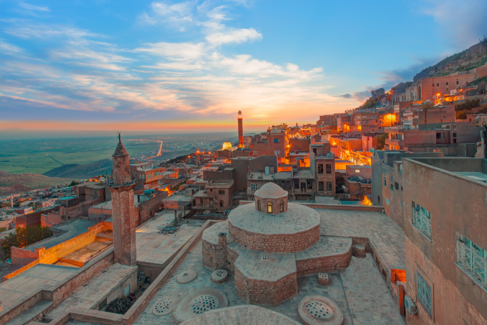 <p>The ancient buildings in Mardin, Turkey are built up the slopes of a mountain, with an ancient citadel on top. One of those buildings will definitely have a rooftop cafe where you can enjoy a perfect Turkish coffee and meal while looking out on the plains of Mesopotamia, the birthplace of civilization.</p>