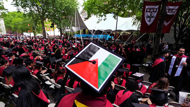 A student displays the Palestinian flag on his mortar board as graduates take their seats in Harvard Yard during commencement at Harvard University, Thursday, May 23, 2024, in Cambridge, Mass. Harvard University said Tuesday, May 28, 2024, that it would no longer take positions on issues that are not “relevant to the core function of the university.”