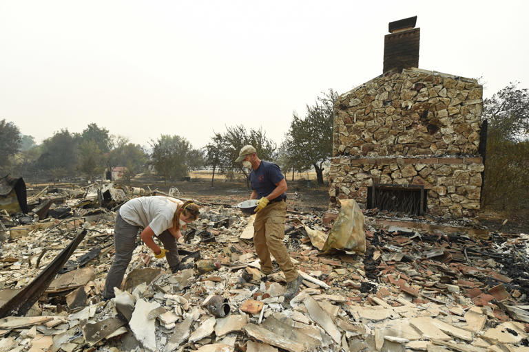 VACAVILLE, CA - AUGUST 20: Sarah Hawkins, of Vacaville, and her husband Andy dig through the rubble after their home was destroyed by a fire in Vacaville, Calif., on Thursday, Aug. 20, 2020. The LNU Lightning Complex fires began in Napa and Sonoma counties and have traveled into Solano, Lake and Yolo counties while burning more than 200 square miles.