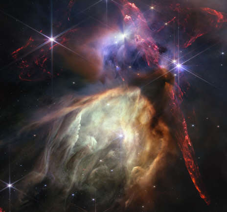 NASA's James Webb Space Telescope reveals the Rho Ophiuchi cloud complex, the closest star-forming region to Earth on July 12, 2023 in space. The young stars at the center of many of these disks are similar in mass to the Sun, or smaller. The heftiest in this image is the star S1, which appears amid a glowing cave it is carving out with its stellar winds in the lower half of the image. The lighter-colored gas surrounding S1 consists of polycyclic aromatic hydrocarbons, a family of carbon-based molecules that are among the most common compounds found in space. These images are a composite of separate exposures acquired by the James Webb Space Telescope using the NIRCam instrument. Several filters were used to sample wide and narrow wavelength ranges. The color results from assigning different hues (colors) to each monochromatic (grayscale) image associated with an individual filter.
