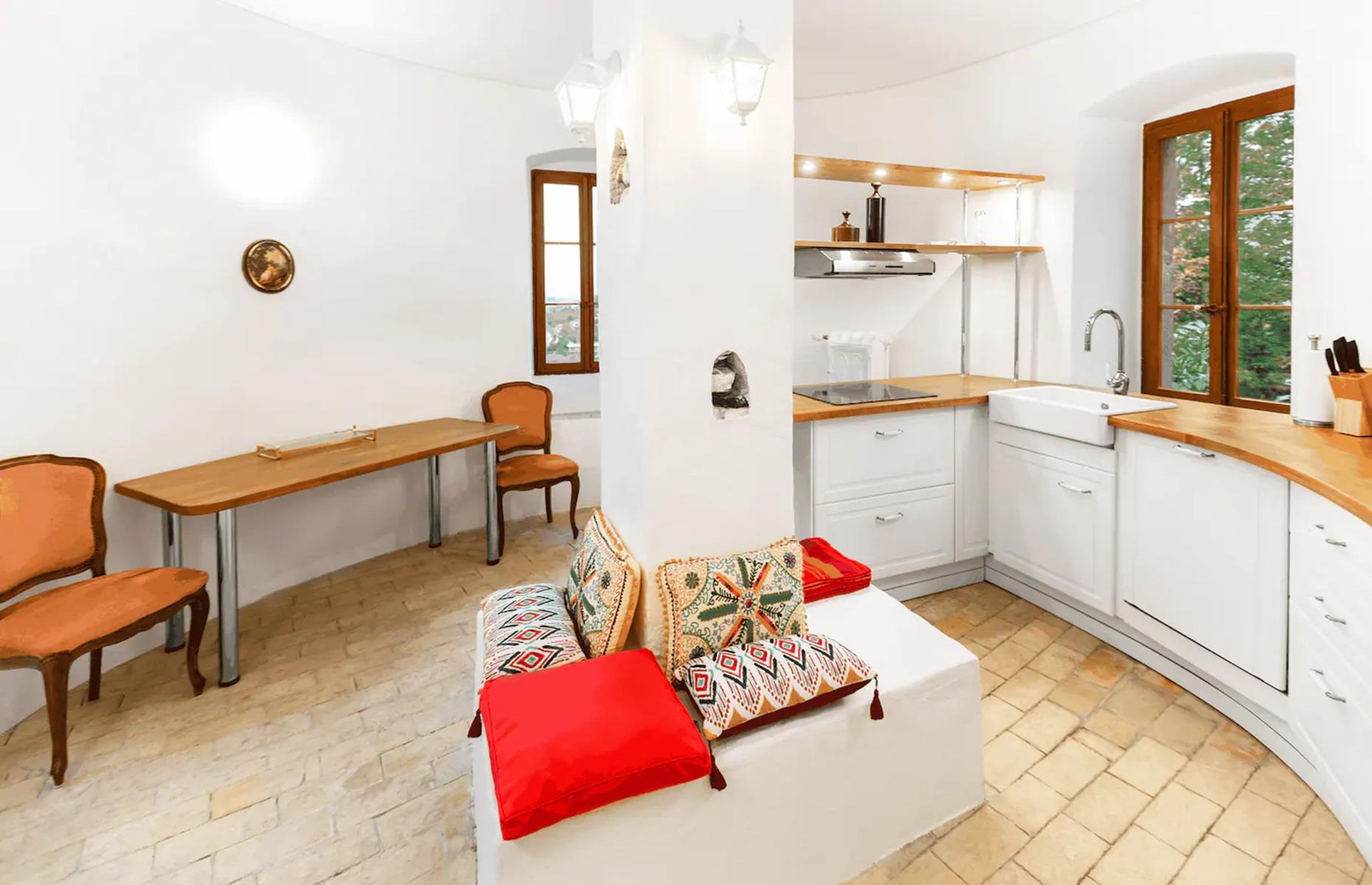 <p>The castle is home to endless suites and apartments and this particular one is available to rent <a href="https://www.airbnb.co.uk/rooms/40606474?source_impression_id=p3_1716963577_rFeYIfkDWDXLcP7z">via Airbnb</a>.</p>  <p>Quirky and full of character, the apartment comes complete with an open-plan living space, with a bed tucked away in an alcove. There's also a rounded kitchen with a dining zone.</p>
