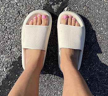 reviewer wearing the beige sandals outside