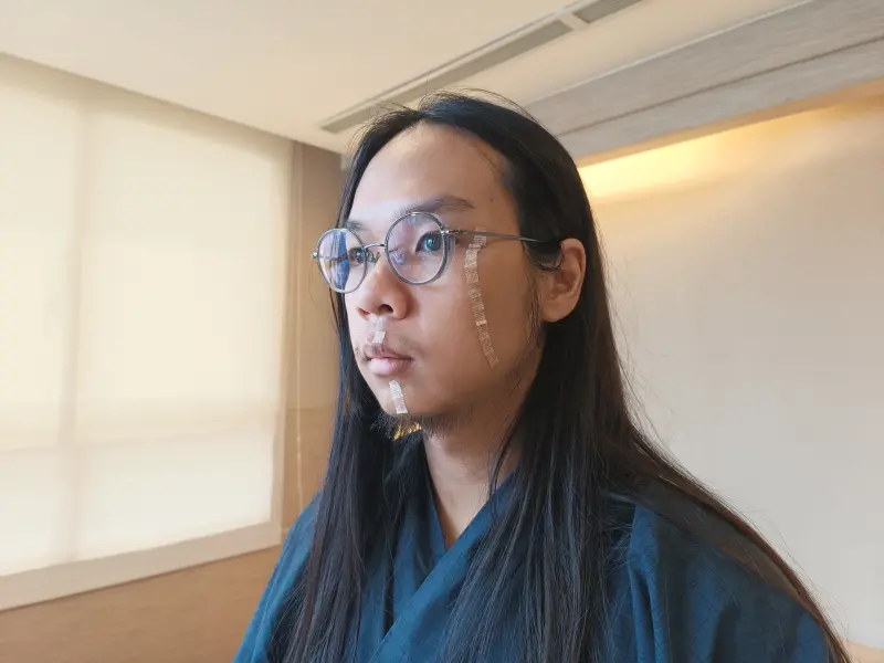 ▲今天「長髮哥」許瑞顯親自出庭作證，表示左顴骨的大面積刀傷，是雙方尚未發生肢體接觸前，就已遭洪嫌持菜刀砍傷。（圖／翻攝畫面）