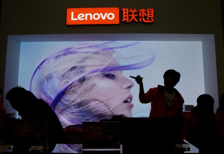 An employee gestures next to a Lenovo logo at Lenovo Tech World in Beijing, China November 15, 2019. Photo: Reuters