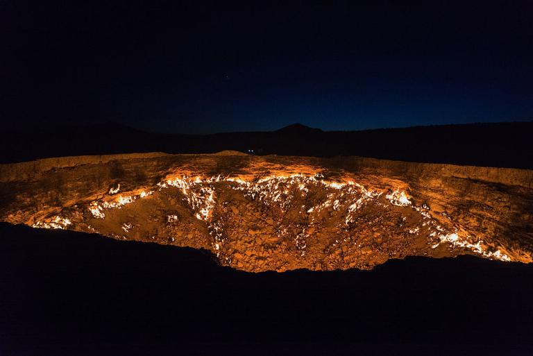 <p>This incredible image is taken of the Darvaza Gas Crater is in Derweze, Turkmenistan. Its proper name is the Darvaza Gas Crater, but many call it the "Door to Hell." This is the only hole on fire and continues to burn more than four decades later.</p> <p>That's right, the Soviet scientists allegedly hit gas during a drilling accident, which set the hole on fire and the result has yet to be extinguished. Darvaza Gas Crater is 225 feet wide and 99 feet deep. You can see the glow it emits from a mile away.</p> <p><b><a href="https://www.exploredplanet.com/guides/wild-little-known-geography-facts/" rel="noopener noreferrer">Read More: Geography Facts That Will Have You Questioning Your Place On Earth</a></b></p>