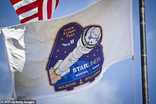 Pictured, a flag bearing the mission logo for Boeing Starliner's first crewed test flight, waving above at Kennedy Space Center in Cape Canaveral, Florida, on May 3 2024, just days before the cancelled launch 