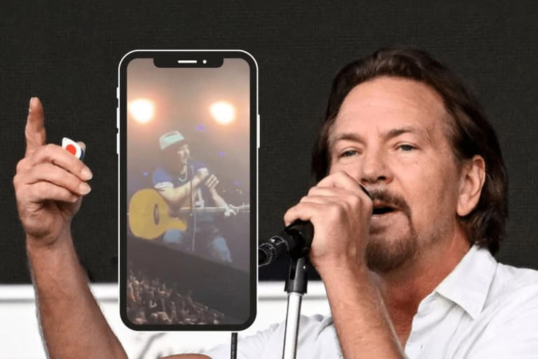 Pearl Jam singer Eddie Vedder points finger in the air while singing, screenshot of Vedder playing acoustic guitar in cell phone screen frame
