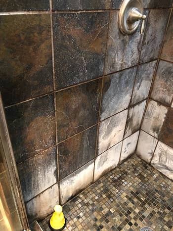 a reviewer photo of a shower wall with white build.-up on the walls