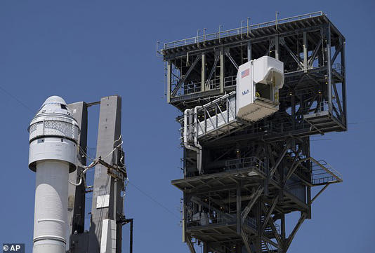 Above, a 'crew access arm' pictured before it is swung into position allowing astronauts to board Boeing's CST-100 Starliner which has been positioned on the launchpad at Space Launch Complex 41 this week ahead of the NASA/Boeing Crew Flight Test