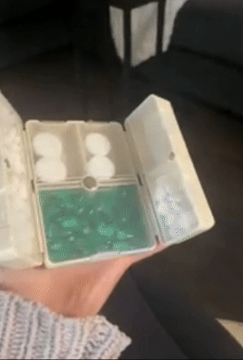 Reviewer holding a white version of the organizer and snapping it closed with one hand
