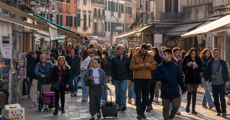 Tourists line a street in Venice, Italy, on Saturday, March 16, 2024. Venice collected €37 million in overnight tourist taxes in 2023, with hotels charging guests anywhere between €1 and €5. 