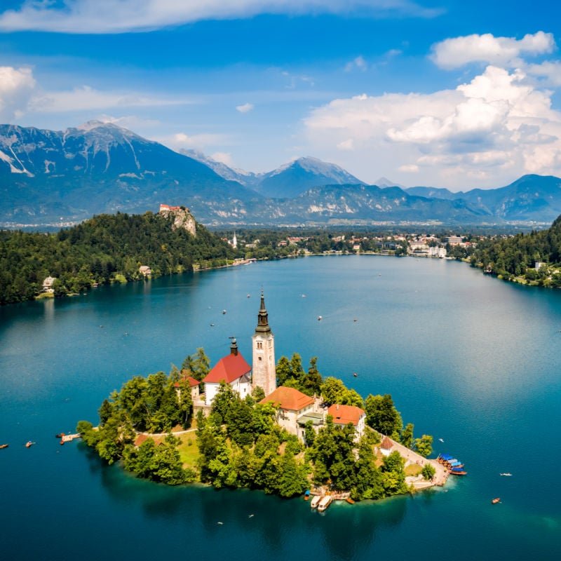Tucked away between the larger and more popular countries of Italy and Croatia, <a href="https://www.traveloffpath.com/why-this-underrated-european-country-should-be-on-your-bucket-list/" rel="noreferrer noopener">Slovenia</a> is still not on the radar for many travelers. But this small European country is worth visiting, and picturesque Lake Bled is perfect for a summer getaway. With a fairytale-like castle, a charming lakeside town, a little island in the middle of the lake, hiking and cycling trails, and a national park just a five-minute drive away, Lake Bled is the ultimate summer destination.