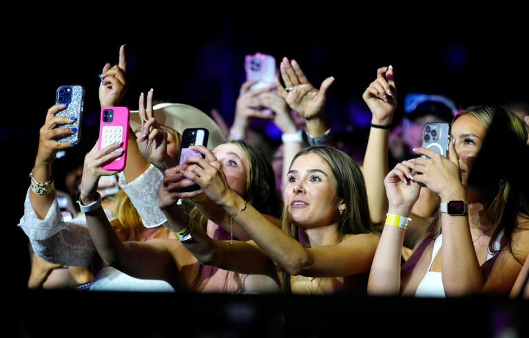 Fans listen and sing along while Luke Combs performs during a concert at State Farm Stadium on May 31, 2024.