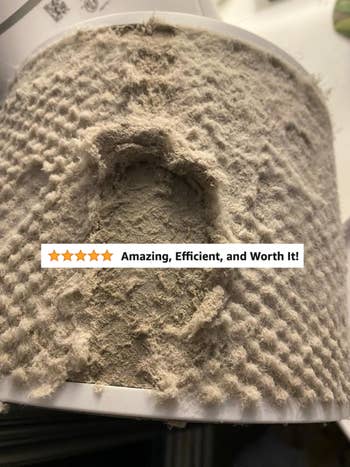 Close-up of a heavily dust-covered filter with a five-star review overlay stating