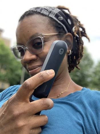 Reviewer holding up small black handheld fan