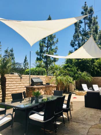 two beige shades set up in a reviewer's back yard