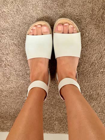 a reviewer wearing the sandals in white