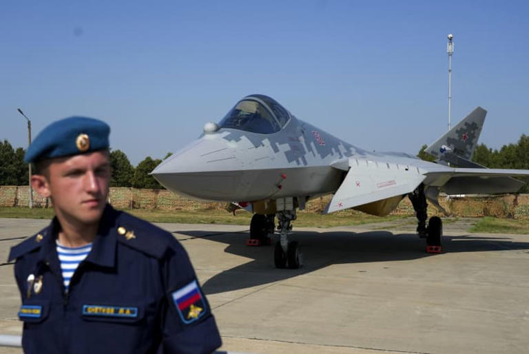 A Russian soldier is seen in front of the Su-57 aircraft during the International Military-Technical Forum 