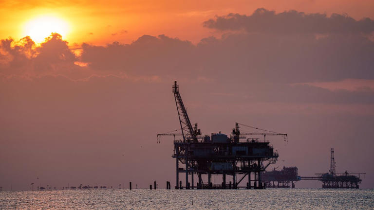 Offshore gas rigs are silhouetted against the setting sun on May 10, 2024, near Fort Morgan, Alabama. Getty Images