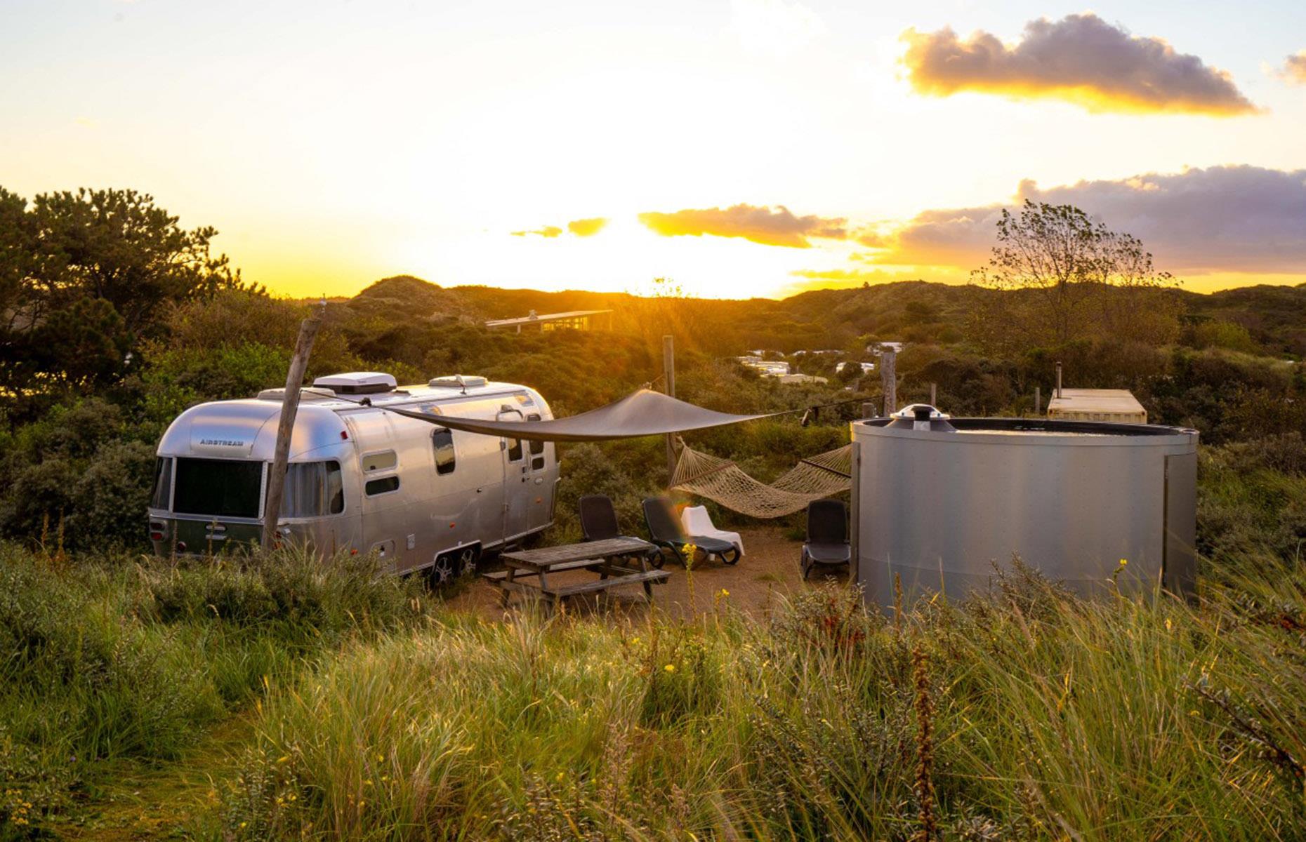 <p>Hidden in a sand dune behind the Netherland’s golden Bloemendaal’s beach, this hip, shiny <a href="https://www.campingdelakens.com/overnachten/accommodaties/accommodatie/102/Airstream">Airstream</a> comes with its own private sauna and a hammock to just kick back and soak up the view. It’s part of the De Lakens camping ground in the heart of the Zuid-Kennemerland National Park, so you’ll have access to all its first-class amenities too.</p>