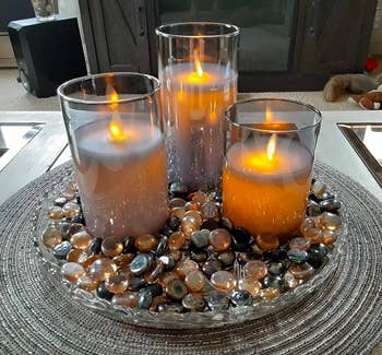 Reviewer image of three flameless candles in a glass dish filled with colorful pebbles