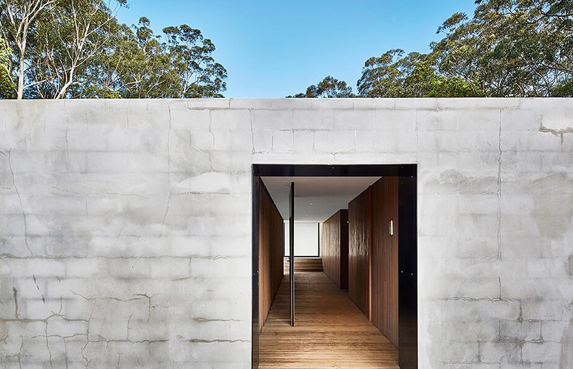 <p>Built by architectural firm <a href="https://www.modscape.com.au/">Modscape</a>, the incredible modular home was designed to be a secret haven from the outside world. </p>  <p>Visitors have to pass through a secret pivoting door in the brick wall to gain access to the hidden property. A timber-lined inner walkway leads to the main living areas, which feature double-height ceilings and warm wood across the floor and walls.</p>