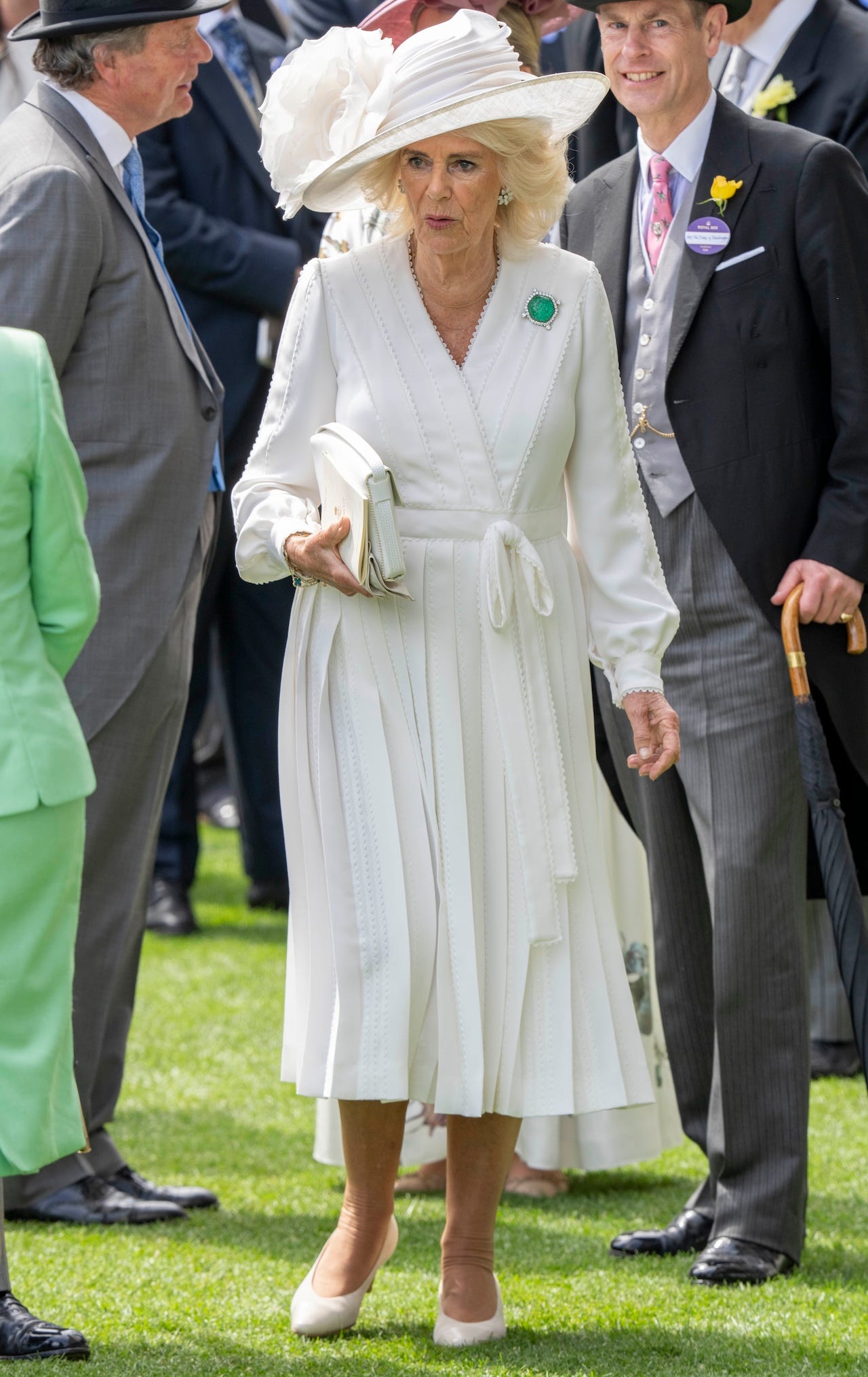 <p>On Thursday, Camilla chose her most summery attire of the week: a white long-sleeved wrap dress and a coordinating white hat with a large floral appliqué.</p><p>She paired her dress with a matching handbag and added a pop of color with the Ladies of India brooch, a piece of emerald-and-diamond jewelry gifted to Queen Mary in the early 1900s, according to <a href="https://www.thecourtjeweller.com/2022/03/the-queen-dazzles-in-diamonds-and-a-major-emerald.html">the Court Jeweller</a>.</p>