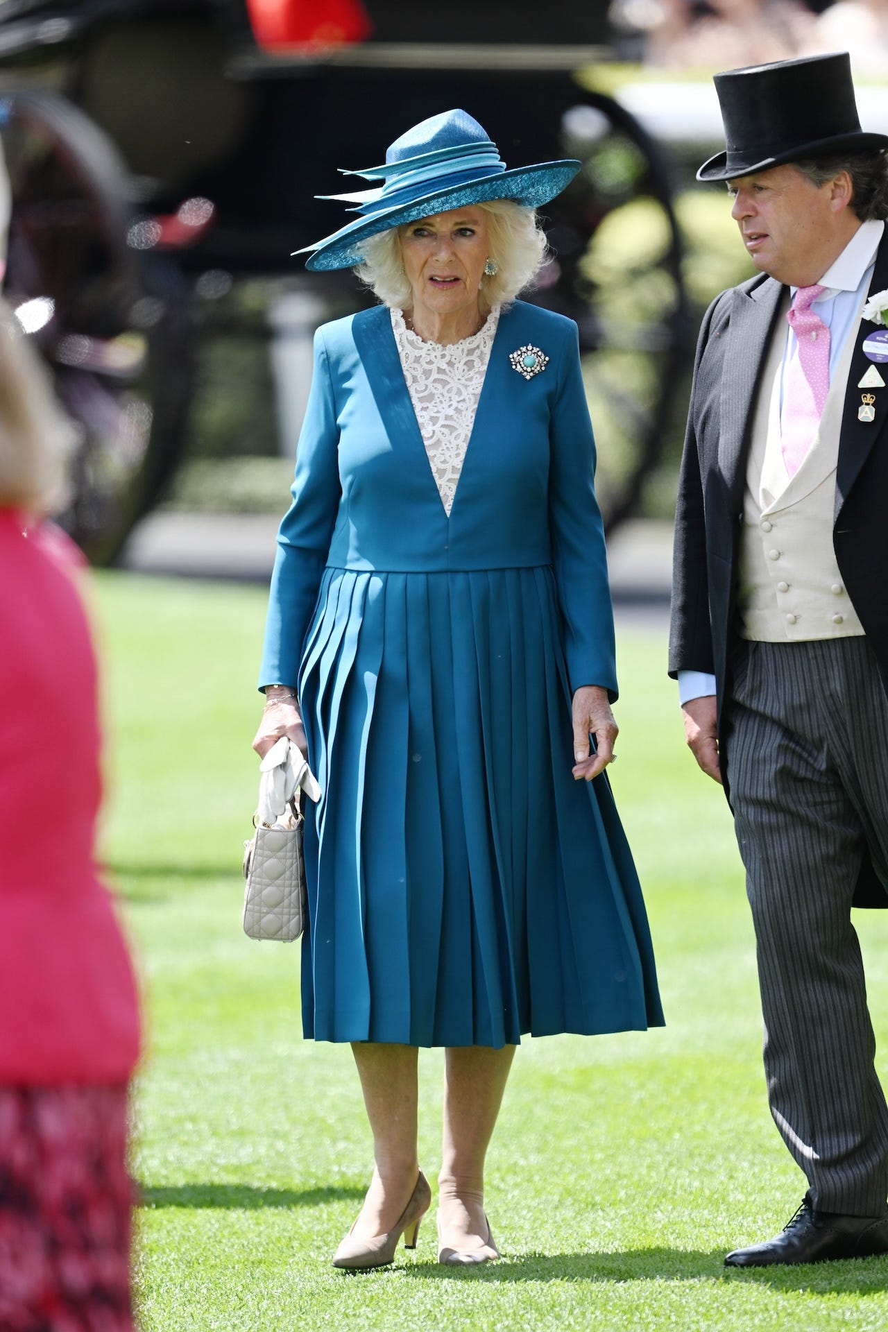 <p>Camilla's day two ensemble consisted of a deep-blue long-sleeved Dior dress with lace detailing down the bodice and a pleated skirt.</p><p>According <a href="https://wwd.com/pop-culture/celebrity-news/queen-camilla-dior-dress-royal-ascot-day-two-queen-elizabeth-brooch-1236454311/">to WWD</a>, she completed her look with a Dior handbag, a layered blue Philip Treacy hat, and a dazzling diamond-and-turquoise brooch that her late mother-in-law, Queen Elizabeth II, wore on a royal tour of Malta in 2015.</p>