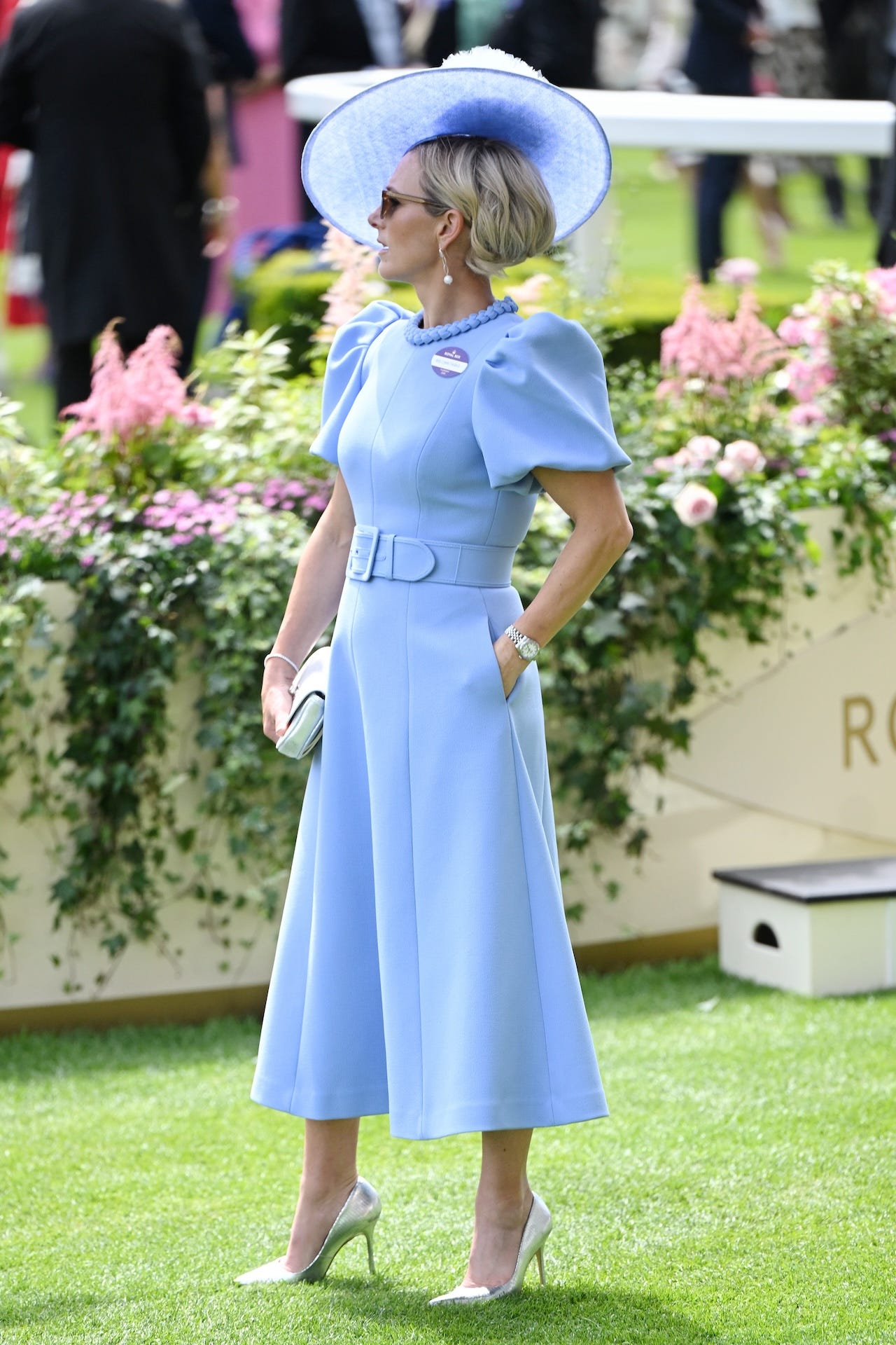 <p>Her latest look consisted of a <a href="https://www.primmsstyle.com/products/rebecca-vallance-puff-sleeve-mini"><span>Rebecca Vallance</span></a><span> baby-blue midi dress with puff sleeves, a knot design around the neckline, and a built-in belt. Zara paired the dress, which was on sale for $367, with light pumps, a silver watch and jewelry, a clutch, and a coordinating fascinator. </span></p>