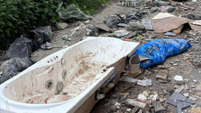 bath and carpets among rubbish fly-tipped on road