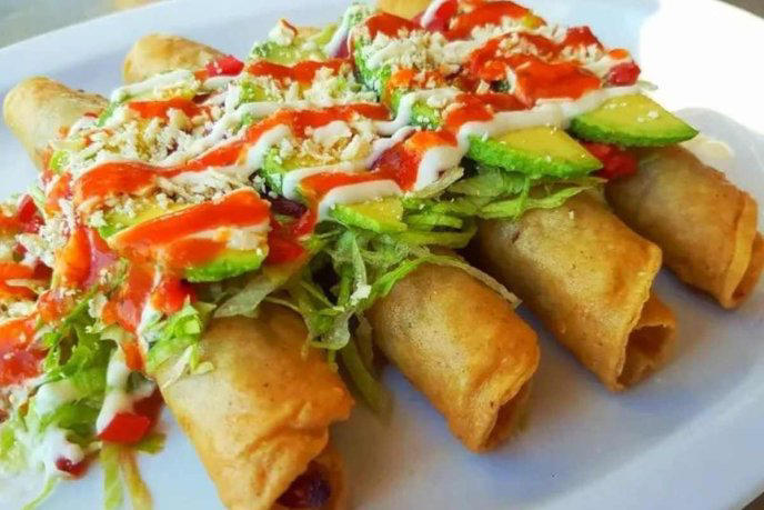 Flautas de res sobre plato blanco 