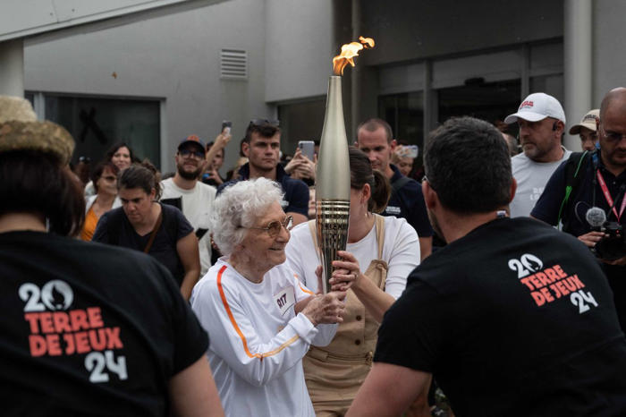 102-jährige trägt das olympische feuer