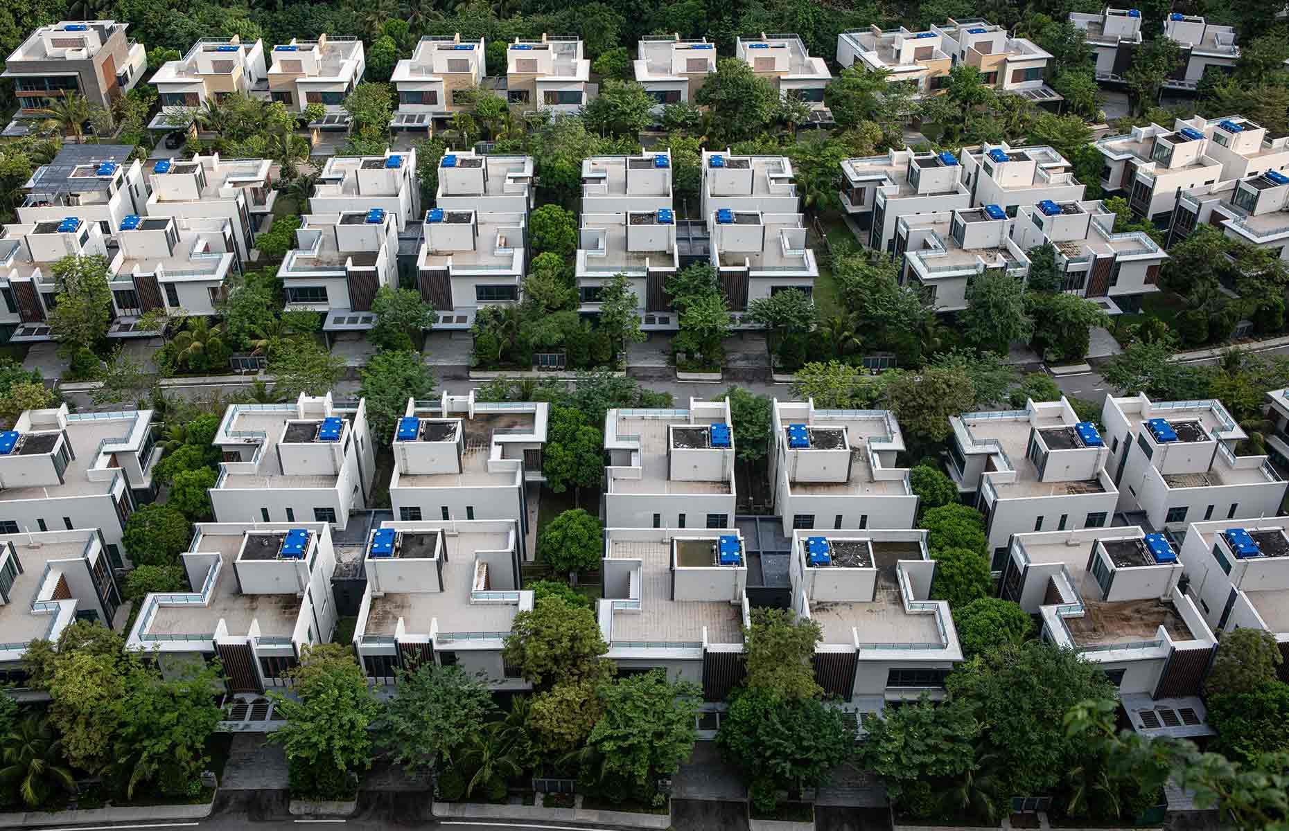 <p>Pictured here, rows of cookie-cutter villas sit in the shadow of Forest City's high-rise towers. Many seem to still be under construction, while signs of neglect are apparent from the roof terraces, some of which are flooded and mouldering. </p>  <p>Unfortunately, China's property crisis in 2021 couldn't have come at a worse time for the fledgling city. Country Garden, once a behemoth of China's housing sector, now reportedly faces debts of $200 billion. While the beleaguered developers told the <em>BBC</em> that they were "optimistic" that Forest City would be completed, that likelihood appears to be dwindling. Country Garden is now in the midst of a liquidation hearing to decide the future of the company.</p>