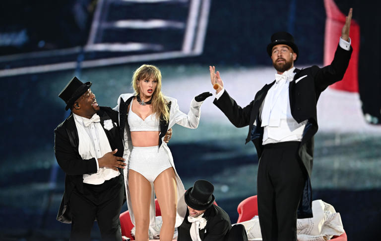 Swifties went wild when Taylor Swift's boyfriend, Travis Kelce, right, appeared onstage for a bit on June 23. The football player attended all three sold-out shows — with a long list of other VIPs. (Gareth Cattermole/TAS24/Getty Images for TAS Rights Management )