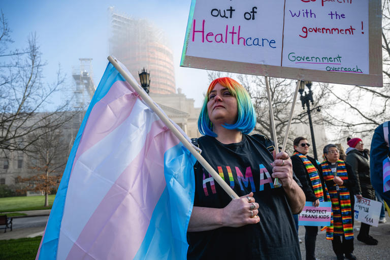 Sarah Newton stands with a trans pride flag during a rally to protest the passing of SB 150 on March 29, 2023, at the Kentucky State Capitol in Frankfort, Kentucky.