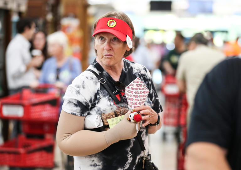 Goldie Lowery carries an armful of goods while wearing a Buc-ee's visor she was going to purchase during her visit to the new store in Smith Grove, Kentucky Monday morning June 24, 2024.