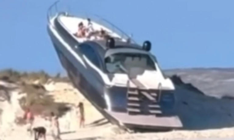 Tourists find luxury yacht and crew on top of sand dune on beach