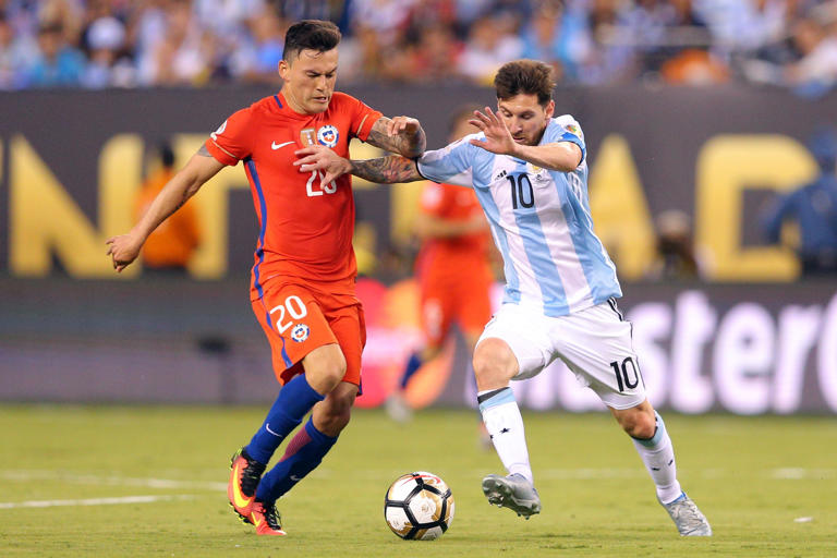 Jun 26, 2016; East Rutherford, NJ, USA; Chile midfielder Charles Aranguiz (20) and Argentina midfielder Lionel Messi (10) fight for the ball during the championship match of the 2016 Copa America Centenario soccer tournament at MetLife Stadium. Chile defeated Argentina 0-0 (4-2). Mandatory Credit: Brad Penner-USA TODAY Sports