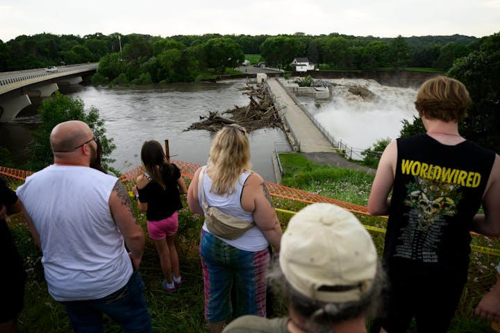 People gather to watch the Rapidan Dam on Monday, June 24, 2024 near Mankato. Water in the river significantly cut around the west side of the dam, which is 12 miles southwest of Mankato.