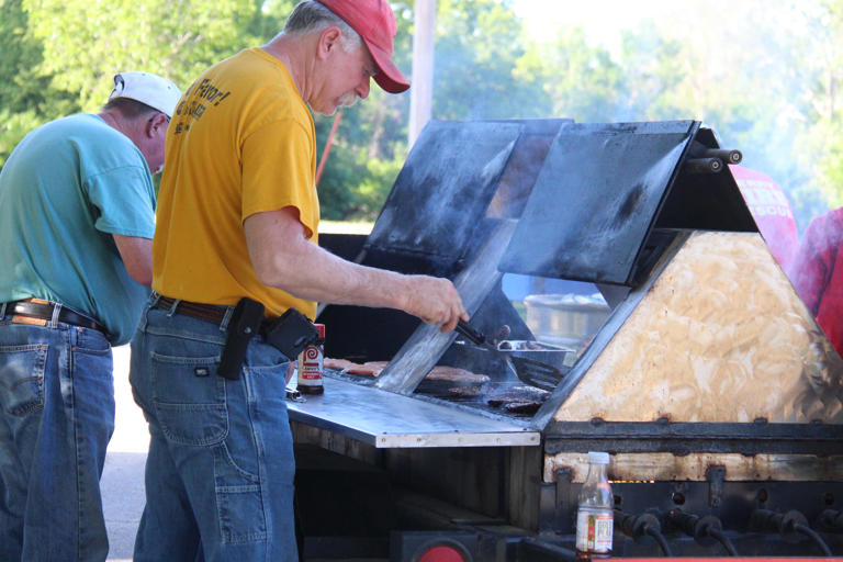 Members of the Perry Volunteer Fire Department grill hamburgers during Friday Fest on June 3, 2022, at Pattee Park.