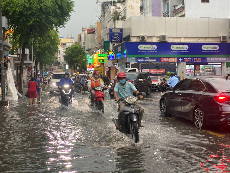 Tiền Phong Người dân vất vả di chuyển trong cơn mưa tại TPHCM chiều 14/6. Ảnh: Hữu Huy 1