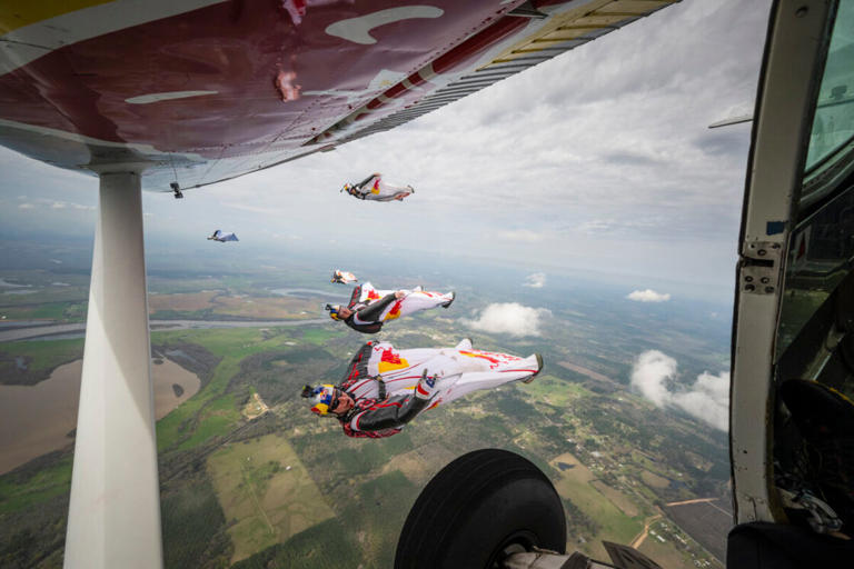 Red Bull Air Force team members Andy Farrington, Mike Swanson, Jeff Provenzano, and Miles Daisher wingsuit fly alongside the Plane Swap plane (flown by Luke Aikins) at the Red Bull Aviation Camp in Coushatta, Louisiana, USA on March 7, 2024.