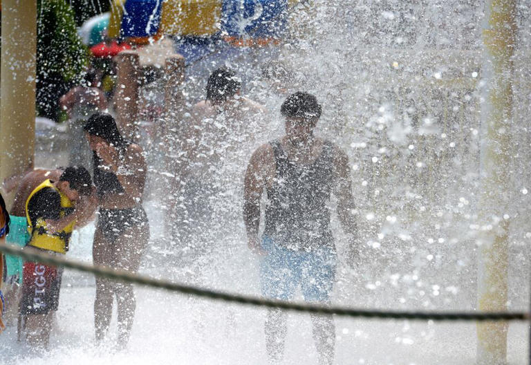 Guests are drenched by a giant bucket of water at Six Flags New England's Hurricane Harbor waterpark in Agawam. (Don Treeger / The Republican) 7/24/2023