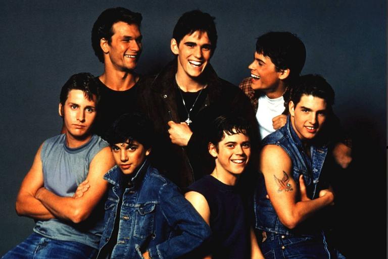 <p>For the movie's poster, the initial idea was for the Greasers to be in character for the picture, but it didn't pan out that way. The reaction on the actors' faces occurred after Lief Garrett, who played Bob, went to the catering table and was denied by the stagehand who didn't believe that he was part of the film. </p> <p>After Garrett was denied, Macchio joked, saying, "Yeah, it's for the talent." This prompted the boys to burst into laughter, giving us the movie poster we see today. </p>