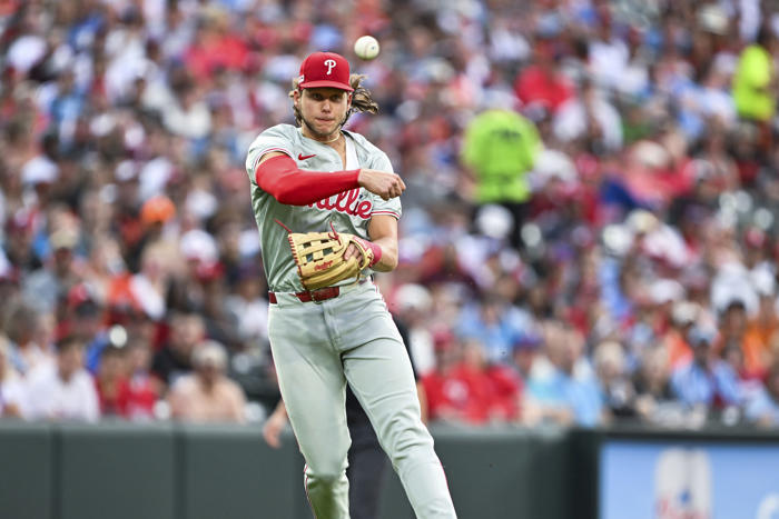 phillies wait out an extra-inning rain delay, then outlast the orioles 5-3 in 11